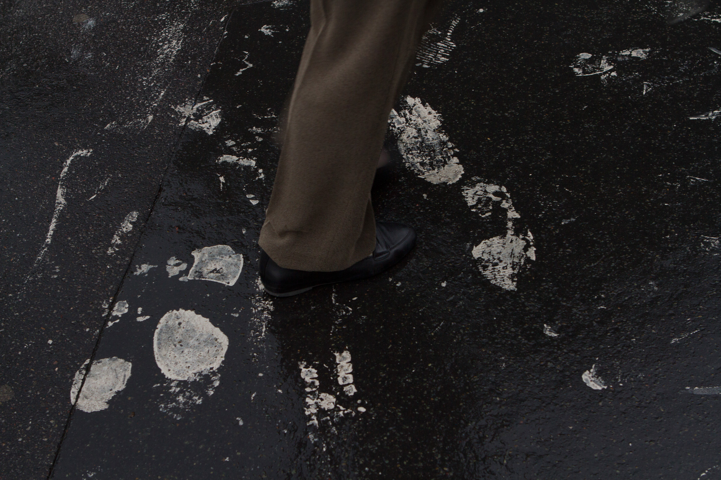 man stepping in paint footsteps of white paint